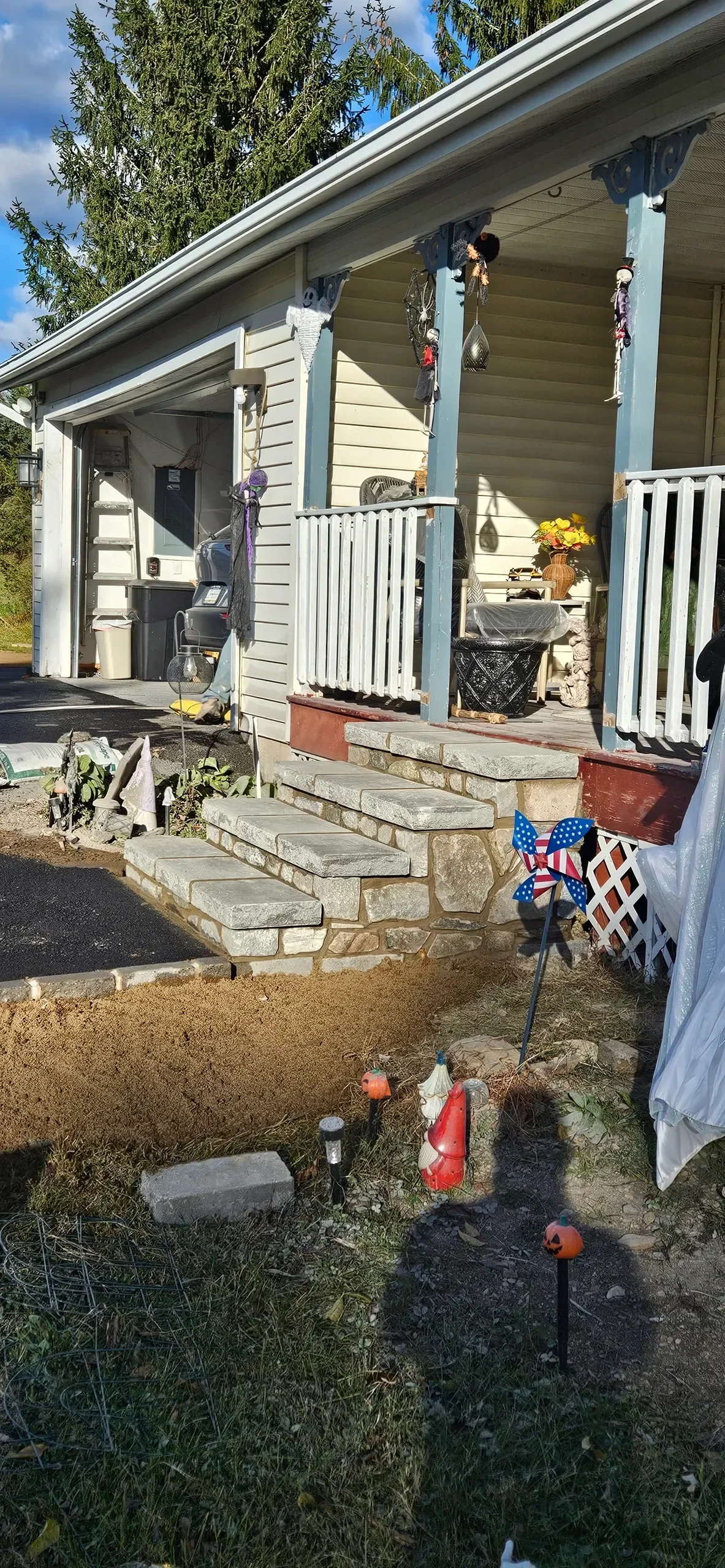 Newly crafted stone steps lead to a porch that is ready for final landscaping.