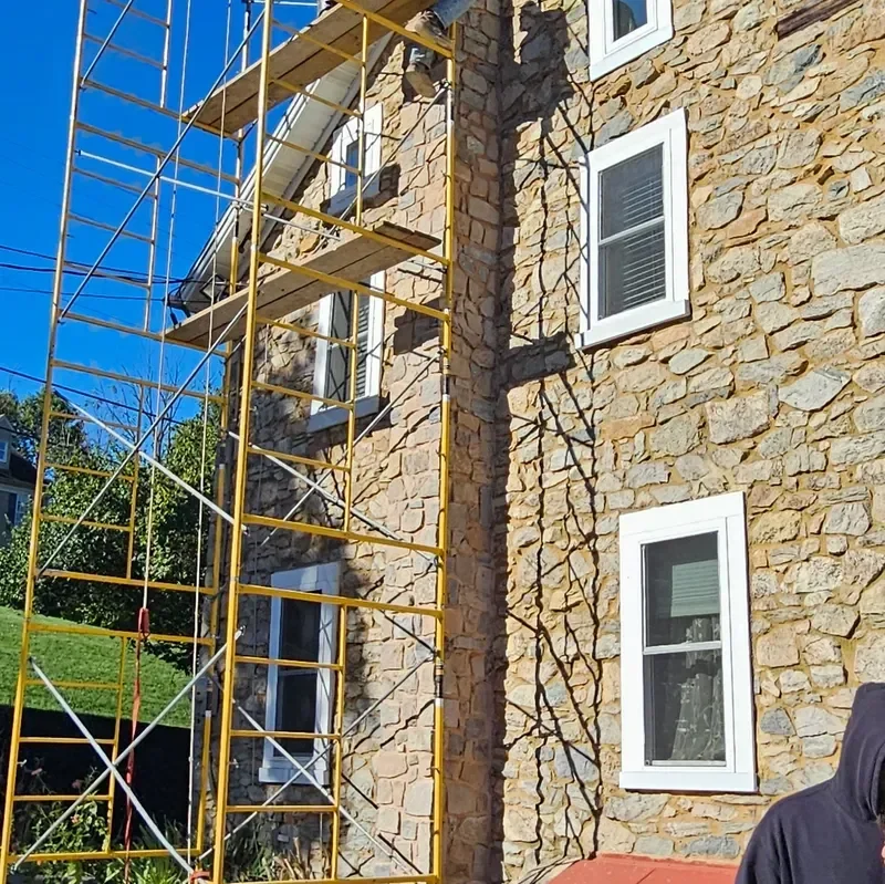 Yellow scaffolding lines a stone facade that is undergoing repair work.