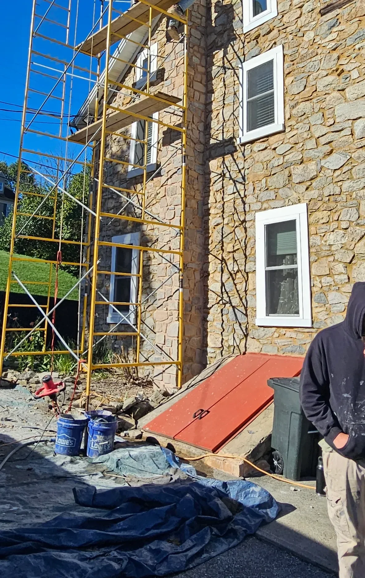 Scaffolding surrounds a stone building during exterior restoration.
